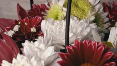 Flowers in a basket of chrysanthemums of different colors are spinning. Gift bouquet of flowers. Large beautiful flowers rotate and smell.