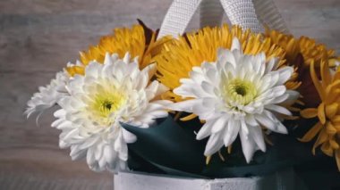 Flowers in a basket of chrysanthemums of different colors are spinning. Gift bouquet of flowers. Large beautiful flowers rotate and smell.