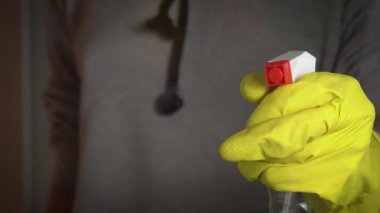 Eldivenli kadın elleri pencereyi sprey sıvıyla yıkıyor. Ev hanımı ev işi yapar. Şeffaf parlak camları tozdan temizlemek.