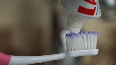 Toothpaste climbs out of the tube onto the toothbrush close-up. Apply toothpaste to the brush. Morning brushing of teeth. Take care of your teeth. Daily hygiene.