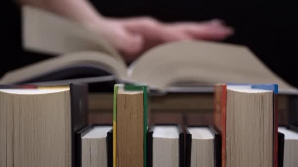 Ένα Νεαρό Κορίτσι Διαβάζει Ένα Βιβλίο Στο Φόντο Ενός Ραφιού — Αρχείο Βίντεο