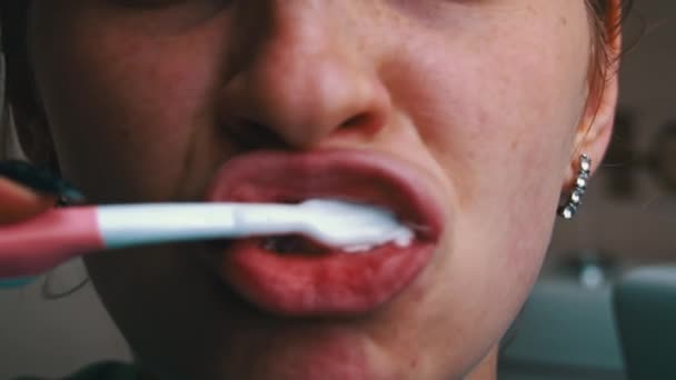 在上午的特写中 女孩用刷子刷牙 把牙膏涂在刷子上 早上刷牙 照顾好你的牙齿日常卫生 — 图库视频影像