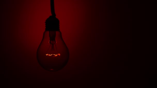 Light Bulb Lights Red Background Dark Slow Turning Tungsten Bulb — Stok video