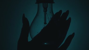 Ampul, karanlıkta bir insan elinin dokunuşuyla açılıp söner. Tungsten ampulü yavaş yavaş açıp kapanıyor. Yanıp sönen eski bir ampulün filamanı. Enerji, elektrik, ışık