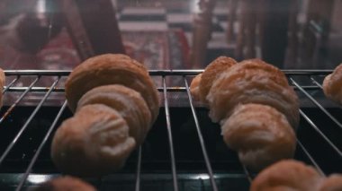 Ev hanımı fırın manzarasından hazır kruvasan alıyor. Ev yapımı puf böreği. Kadın sıcak çörekleri çıkarıyor. Lezzetli iştah açıcı yemekler. Baker pişmiş kruvasanları fırından çıkarıyor..