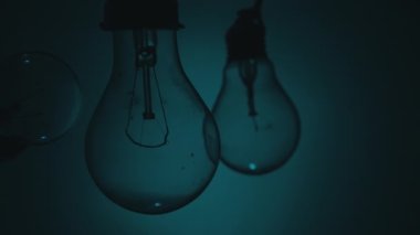 Light bulb turns on and goes out at the touch of a persons hand in the dark. Slow turning on and off of a tungsten light bulb. Filament of a blinking vintage light bulb. Energy, electricity, light