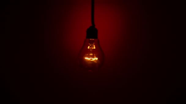 Лампочка Шатается Красном Фоне Темноте Медленное Включение Выключение Лампочки Вольфрама — стоковое видео