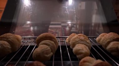 Ev hanımı fırın manzarasından hazır kruvasan alıyor. Ev yapımı puf böreği. Kadın sıcak çörekleri çıkarıyor. Lezzetli iştah açıcı yemekler. Baker pişmiş kruvasanları fırından çıkarıyor..