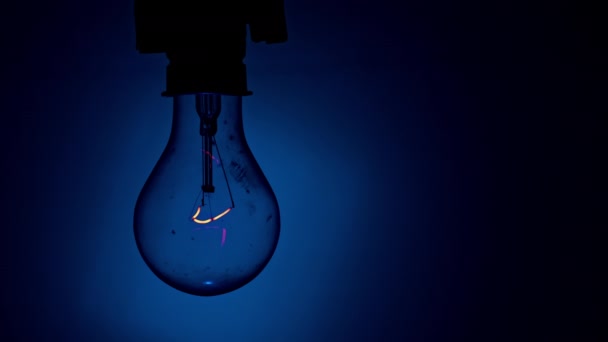 Glühbirnen Leuchten Dunkeln Auf Blauem Hintergrund Langsames Einschalten Der Wolframlampe — Stockvideo