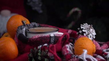 Girl drinks coffee in cozy New Years atmosphere on background of Christmas tree. New Years Eve alone. Screensaver in a cozy atmosphere. The aroma of coffee in a warm cozy blanket.