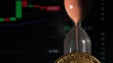 Hourglass on background of crypto-exchange and bitcoin close-up. Time flies like money. Eth and btc quotes on stock exchange. Stock market chart. Buying and selling cryptocurrencies.