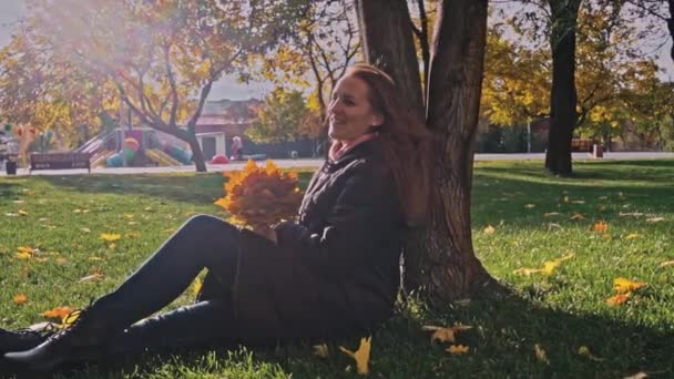 Young Woman Sits Tree Autumn Park Bouquet Maple Leaves Girl — Vídeo de stock