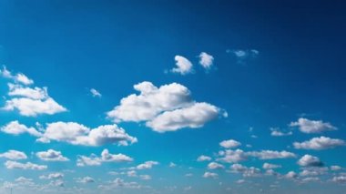 Beyaz kabarık bulutlar mavi gündüz vakti gökyüzünde yavaşça süzülür. Güzel gökyüzü hareket ediyor. Kar beyazı bulutlar yana doğru hareket ediyor..