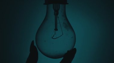 Ampul, karanlıkta bir insan elinin dokunuşuyla açılıp söner. Tungsten ampulü yavaş yavaş açıp kapanıyor. Yanıp sönen eski bir ampulün filamanı. Enerji, elektrik, ışık