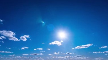 White fluffy clouds slowly float through the blue daytime sky timelapse. Beautiful skies are moving. Airy snow-white clouds move to the side.