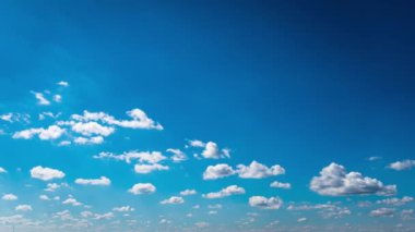 Beyaz kabarık bulutlar mavi gündüz vakti gökyüzünde yavaşça süzülür. Güzel gökyüzü hareket ediyor. Kar beyazı bulutlar yana doğru hareket ediyor..