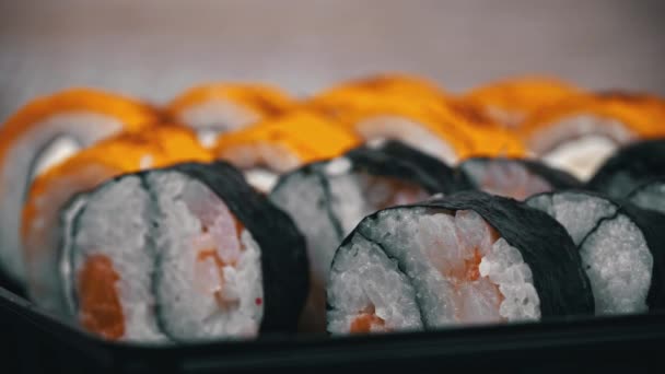 寿司ロールは 寿司を閉じるための箸で取られます レストランで和食寿司 寿司は鮭と野菜で転がす 日本のレストランメニュー サイドビュー — ストック動画