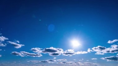 Beyaz kabarık bulutlar mavi gündüz vakti gökyüzünde yavaşça süzülür. Güzel gökyüzü hareket ediyor. Kar beyazı bulutlar yana doğru hareket ediyor..