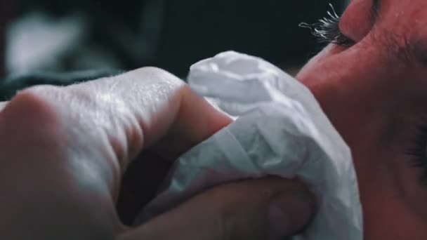 一个红鼻子的男人把他的鼻子吹进了一张白色的餐巾纸里 一个病人流鼻涕 病毒感染 家庭治疗 — 图库视频影像