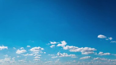 Beyaz kabarık bulutlar mavi gündüz vakti gökyüzünde yavaşça süzülür. Güzel gökyüzü hareket ediyor. Kar beyazı bulutlar yana doğru hareket ediyor..