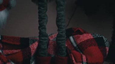 New Years Scandinavian gnome stands near the Christmas tree. A red Christmas elf decorates houses on New Years Eve.