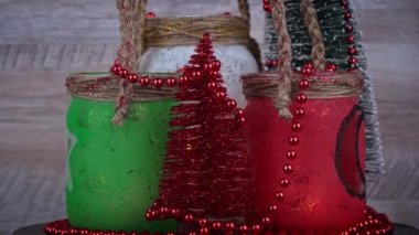 Karda süslü Noel kavanozları bir mumla ve Noel ağaçları dönüşümlü. Noel süsleri, Noel dekorasyonu. Kış tatili atmosferi yeni yıl.
