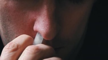 Adam kırmızı burnuna özel bir sprey sıkar. Hasta bir insan burnunun akmasından muzdarip. Viral enfeksiyon. Sağlık hizmetleri. Ev tedavisi.