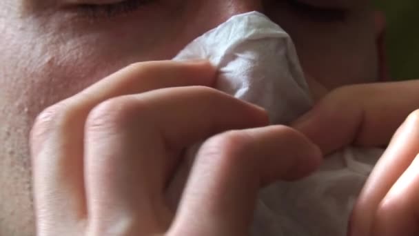 鼻が赤い男は白いナプキンの近くに鼻を吹いた 病気の人は鼻水に苦しむ ウイルス感染症だ 健康管理 在宅治療 — ストック動画