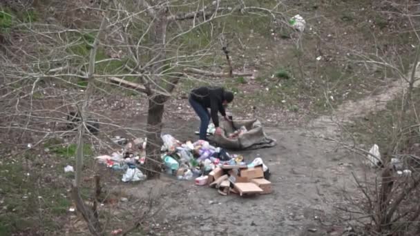 Bezdomny Sortuje Śmieci Obok Dużej Sterty Odpadów Bezdomny Grzebie Śmieciach — Wideo stockowe