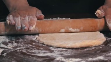 Kadın eli merdaneyle hamuru yuvarlıyor. Ev yapımı un kekleri. Yapışkan hamuru ellerin ağır çekimde diz. Organik taze ekmek. Baker fırında yemek pişiriyor..