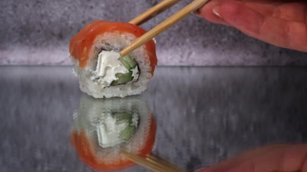 寿司卷是用筷子近距离拍摄的 在餐馆里吃日本料理寿司 寿司卷鲑鱼和蔬菜 日本餐馆菜单 侧视图 — 图库视频影像