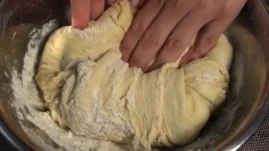 Bir kasede kadın eli ile hamur yoğurmak. Ev yapımı un kekleri. Yapışkan hamuru ellerinle 