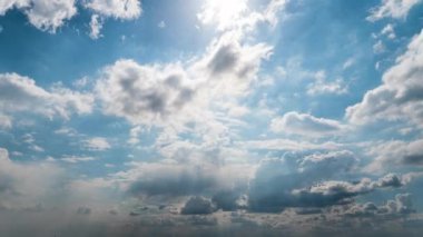 Beyaz kabarık bulutlar mavi gündüz vakti gökyüzünde yavaşça süzülür. Güzel gökyüzü hareket ediyor. Kar beyazı bulutlar yana doğru hareket ediyor..
