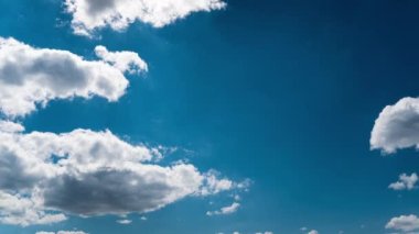 Beyaz kabarık bulutlar mavi gündüz vakti gökyüzünde yavaşça süzülür. Güzel gökyüzü hareket ediyor. Kar beyazı bulutlar yana doğru hareket ediyor..