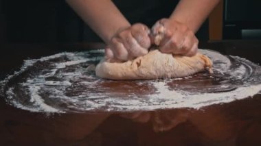 Masaya yakın plan kadın eli ile hamur yoğurmak. Ev yapımı un kekleri. Yapışkan hamuru ellerinle 