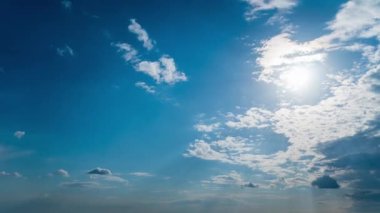 White fluffy clouds slowly float through the blue daytime sky timelapse. Beautiful skies are moving. Airy snow-white clouds move to the side.