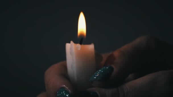 在黑暗的特写中 曼斯的手拿着一支蜡烛 石蜡蜡蜡烛在黑暗中燃烧着黄色的火焰 房子里没有灯 是蜡烛发出的热 沉默的时刻 — 图库视频影像