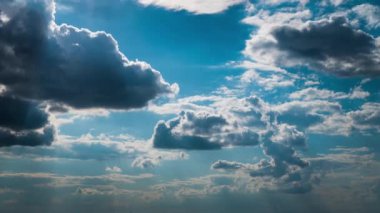 Beyaz kabarık bulutlar mavi gündüz vakti gökyüzünde yavaşça süzülür. Güzel gökyüzü hareket ediyor. Kar beyazı bulutlar yana doğru hareket ediyor..