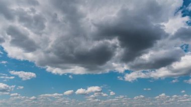 Beyaz kabarık bulutlar mavi gündüz vakti gökyüzünde yavaşça süzülür. Güzel gökyüzü hareket ediyor. Kar beyazı bulutlar yana doğru hareket ediyor..