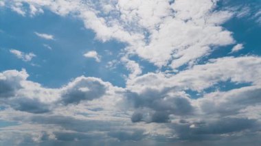 Beyaz kabarık bulutlar mavi gündüz vakti gökyüzünde yavaşça süzülür. Güzel gökyüzü hareket ediyor. Kar beyazı bulutlar yana doğru hareket ediyor..