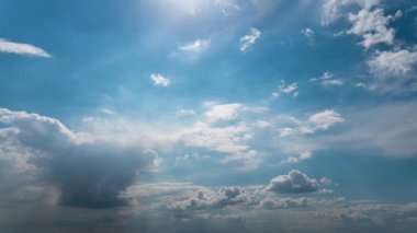 White fluffy clouds slowly float through the blue daytime sky timelapse. Beautiful skies are moving. Airy snow-white clouds move to the side.