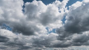 Beyaz kabarık bulutlar mavi gündüz vakti gökyüzünde yavaşça süzülür. Güzel gökyüzü hareket ediyor. Kar beyazı bulutlar yana doğru hareket ediyor..