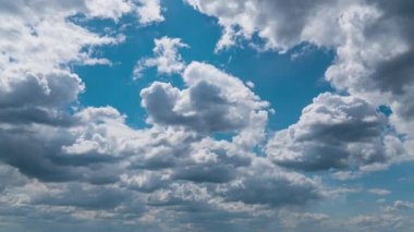 Beyaz kabarık bulutlar mavi gündüz vakti gökyüzünde yavaşça süzülür. Güzel gökyüzü hareket ediyor. Kar beyazı bulutlar yana doğru hareket ediyor..