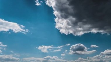 White fluffy clouds slowly float through the blue daytime sky timelapse. Beautiful skies are moving. Airy snow-white clouds move to the side.