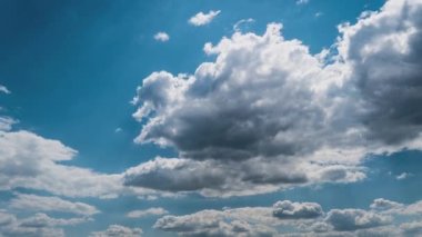 Beyaz kabarık bulutlar mavi gündüz vakti gökyüzünde yavaşça süzülür. Güzel gökyüzü hareket ediyor. Kar beyazı bulutlar yana doğru hareket ediyor..