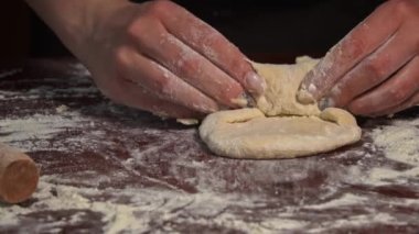 Kadın eli merdaneyle hamuru yuvarlıyor. Ev yapımı un kekleri. Yapışkan hamuru ellerin ağır çekimde diz. Organik taze ekmek. Baker fırında yemek pişiriyor..