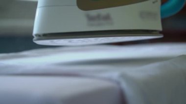 Demir ağır çekimde buhar yayar. Genç bir kadın ütü masasında giysileri ütülüyor. Bir ev hanımı rutin ev işlerini yapar. İşlerle ilgilenmek ve onları düzene sokmak..