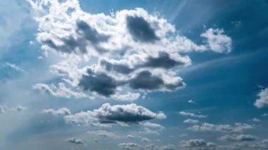 Beyaz kabarık bulutlar mavi gündüz vakti gökyüzünde yavaşça süzülür. Güzel gökyüzü hareket ediyor. Kar beyazı bulutlar yana doğru hareket ediyor..