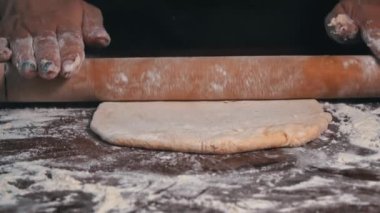 Kadın eli merdaneyle hamuru yuvarlıyor. Ev yapımı un kekleri. Yapışkan hamuru ellerin ağır çekimde diz. Organik taze ekmek. Baker fırında yemek pişiriyor..