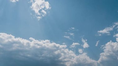 Beyaz kabarık bulutlar mavi gündüz vakti gökyüzünde yavaşça süzülür. Güzel gökyüzü hareket ediyor. Kar beyazı bulutlar yana doğru hareket ediyor..